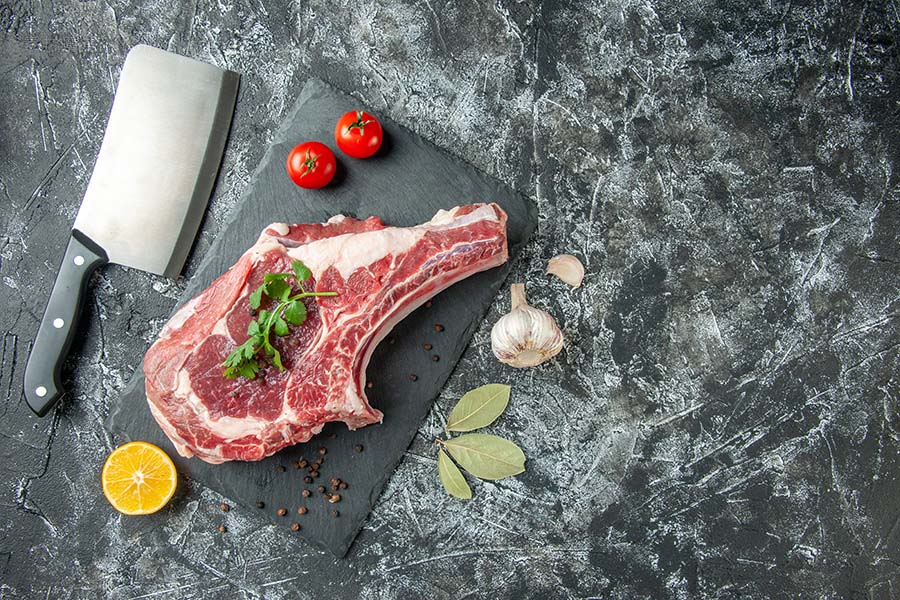 顶视图新鲜肉片配番茄在浅灰色背景厨房动物牛鸡肉食品颜色屠夫肉