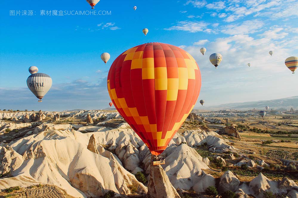 五颜六色的热气球飞行并漂浮在沙漠景观上