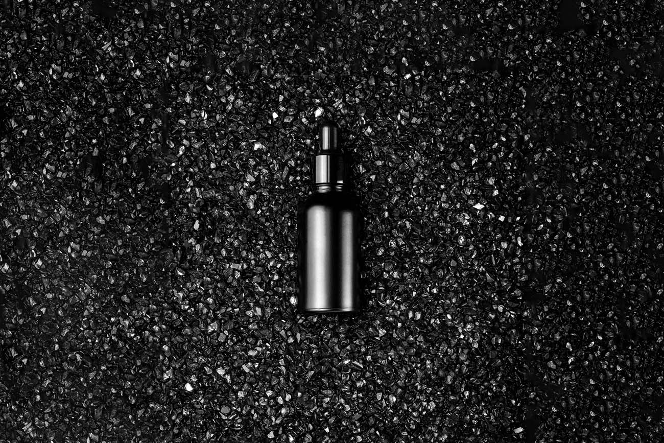 黑色晶体碳上的化妆品瓶样机PSD源文件