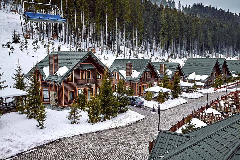 寒假假期木屋在覆盖着雪和蓝天的山上。屋前的滑雪板。