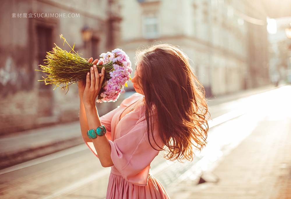站在大街上的女孩闻花香照片girl-smelling-flowers-standing-street