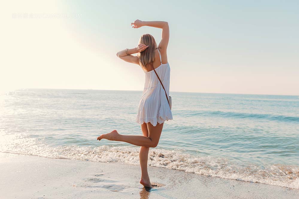 年轻快乐的女人跳舞转身在白色礼服度假海边沙滩阳光灿烂的夏天时尚风格照片young-happy-woma