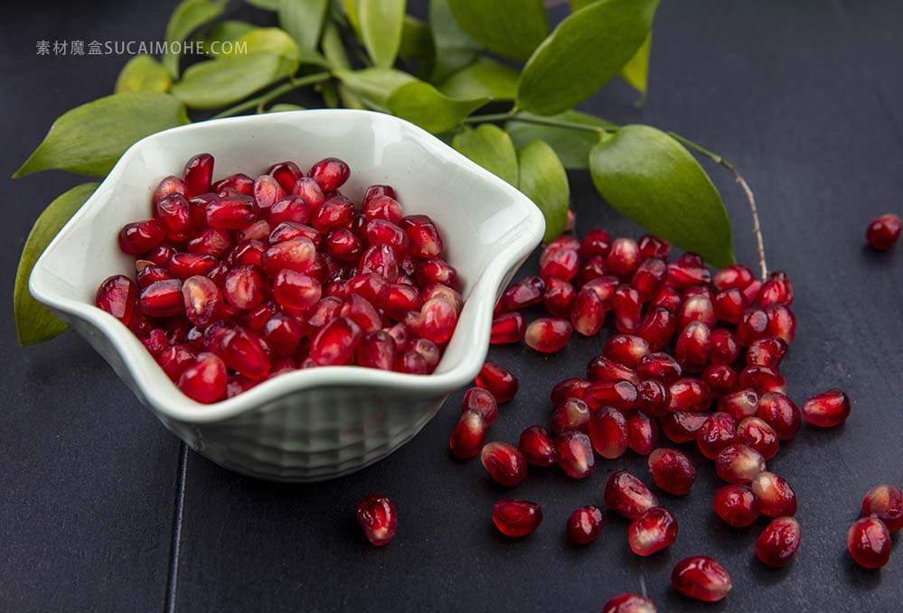 前视图石榴浆果碗叶黑色表面front-view-pomegranate-berries-bowl-leaves-black-surface