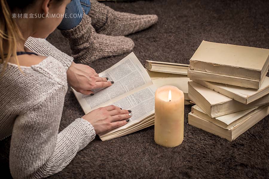 女孩坐在地上被许多白皮书和一支大蜡烛包围照片girl-sitting-floor-surrounded-by-many-white-books-large