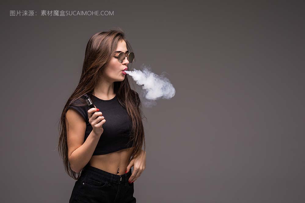 戴着墨镜的年轻女子抽烟抽着电子烟