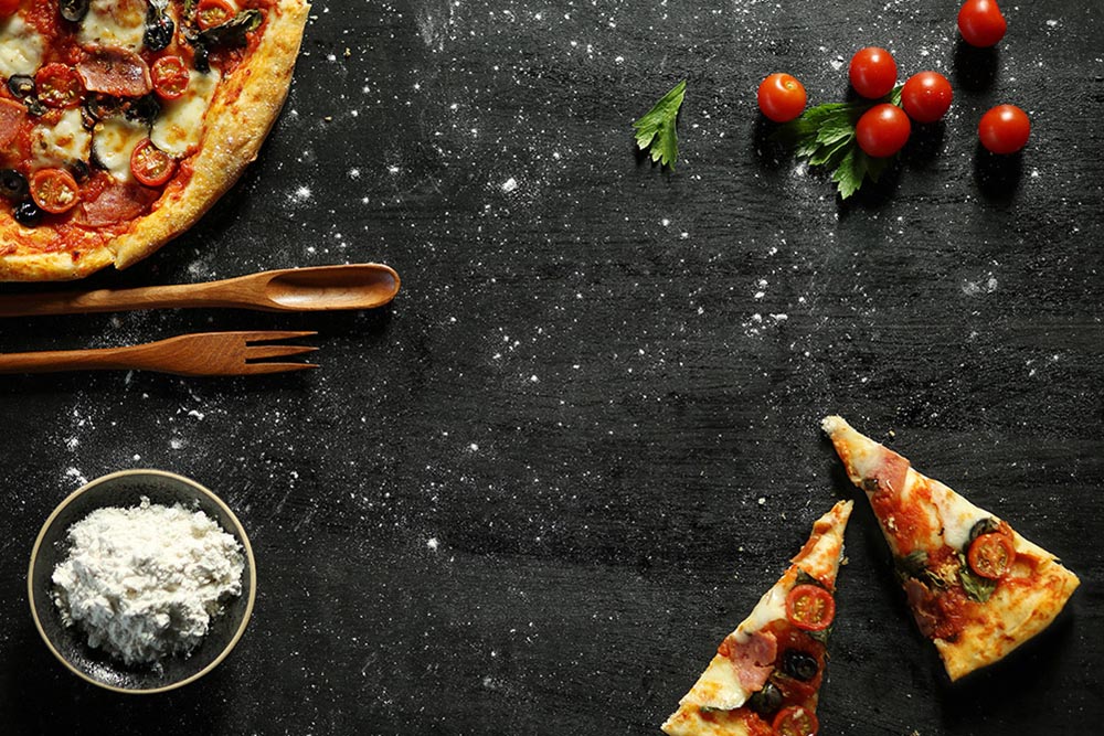 高清摄影大图_messy-pizza-on-a-black-table 披萨 面粉 淀粉 小番茄 圣女果