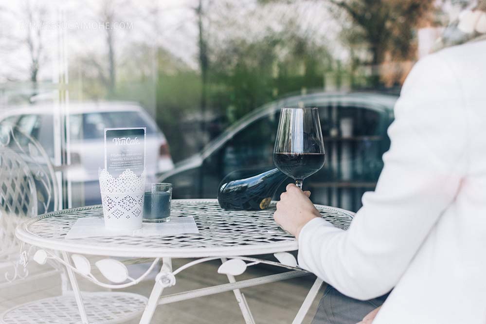 坐在玻璃窗旁边喝红酒的商务人士woman-drinking-red-wine-behind-a-window